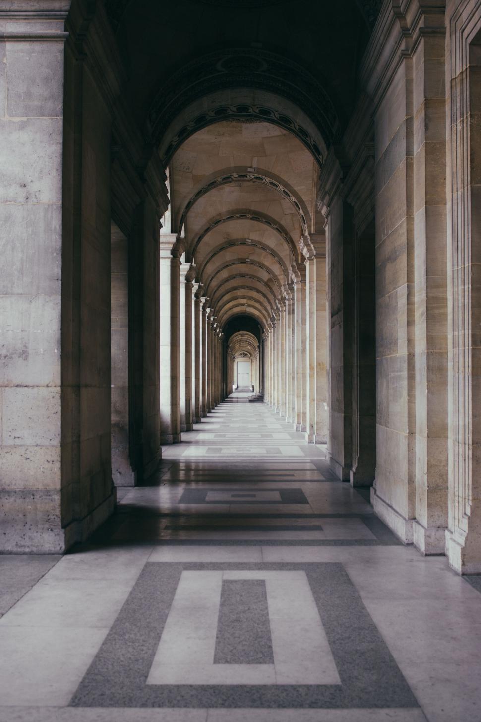 Free Image of A long hallway with arches and columns 