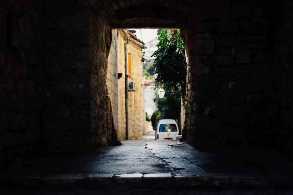 Free Image of A stone archway with a car in the background 