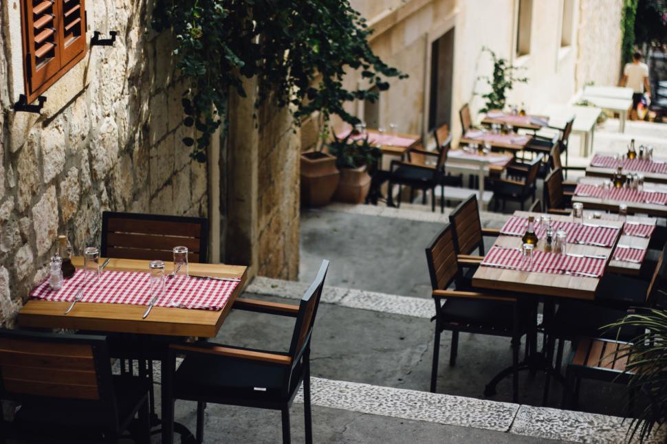 Free Image of Tables outside a restaurant with chairs and tables 