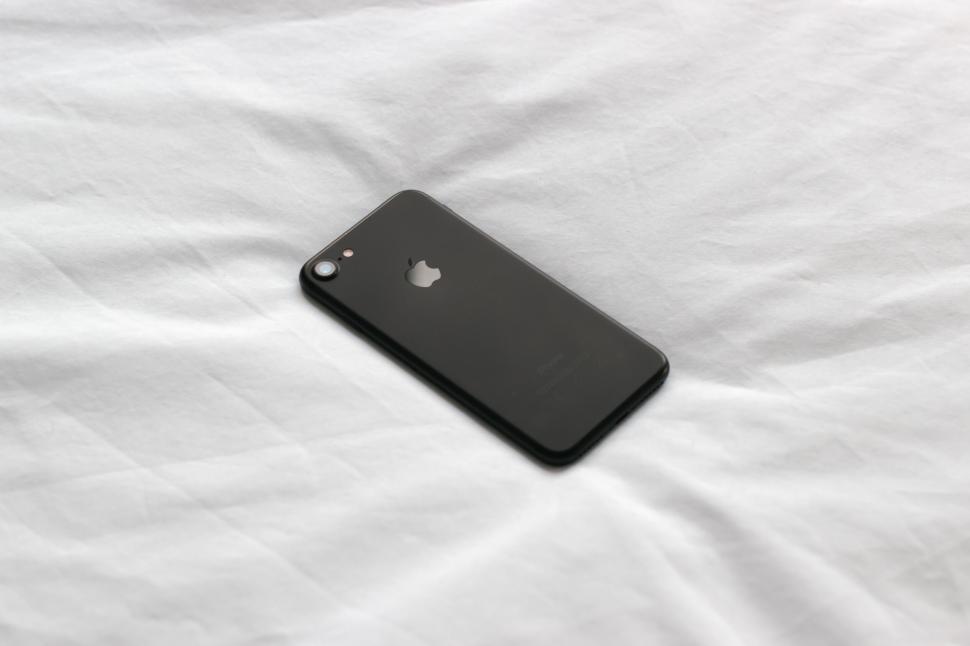 Free Image of A black cell phone on a white sheet 