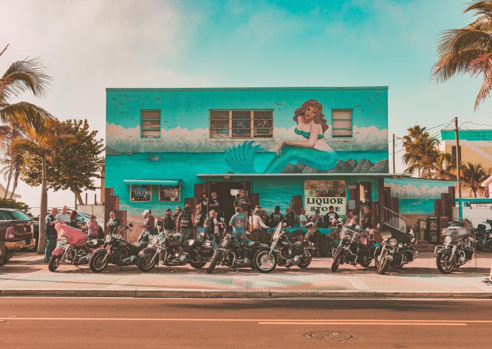 Free Image of A group of people standing in front of a building with motorcycles 