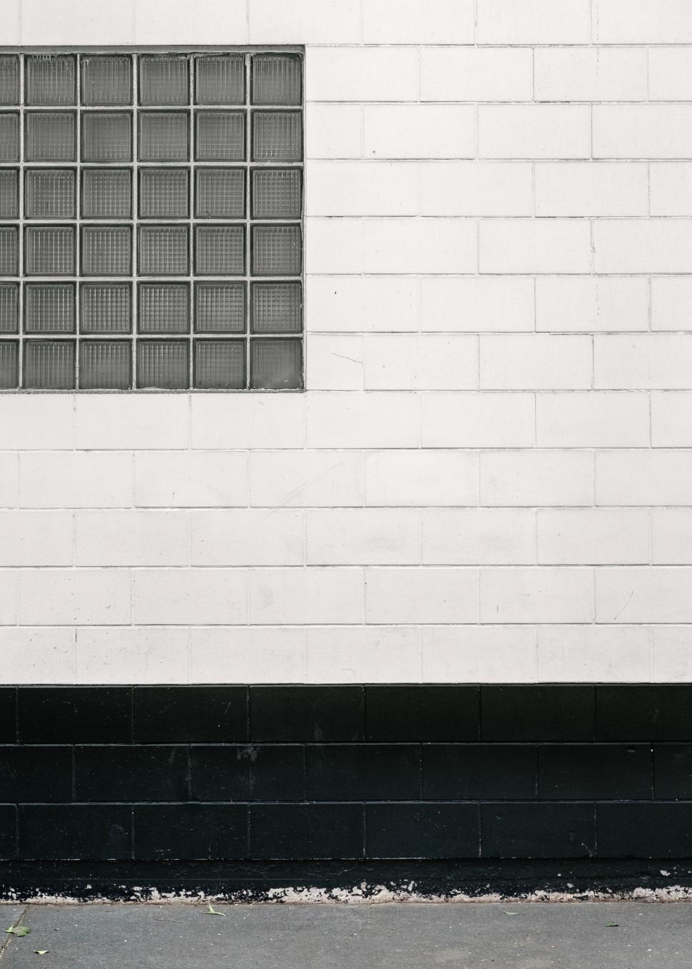 Free Image of wall bricks window street glass white black outside sidewalk road 