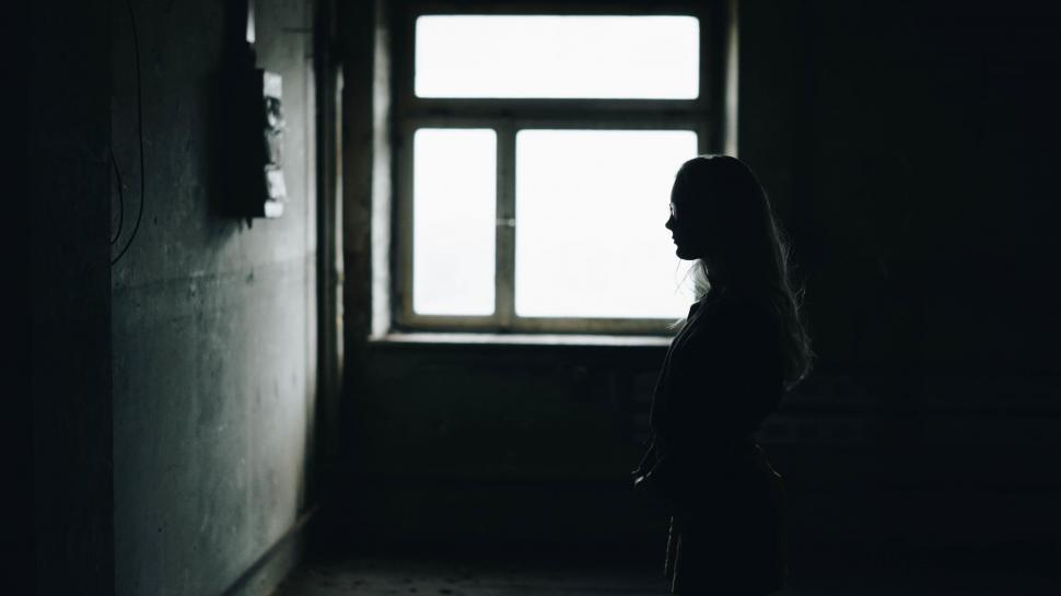 Free Image of A silhouette of a woman in a dark room 