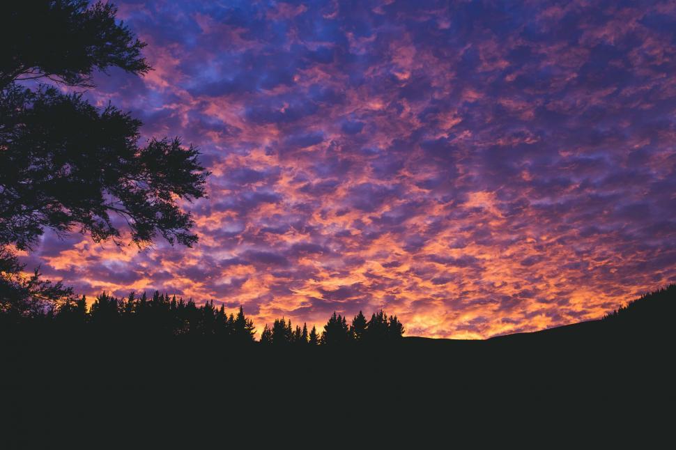 Free Image of A sunset with clouds and trees 