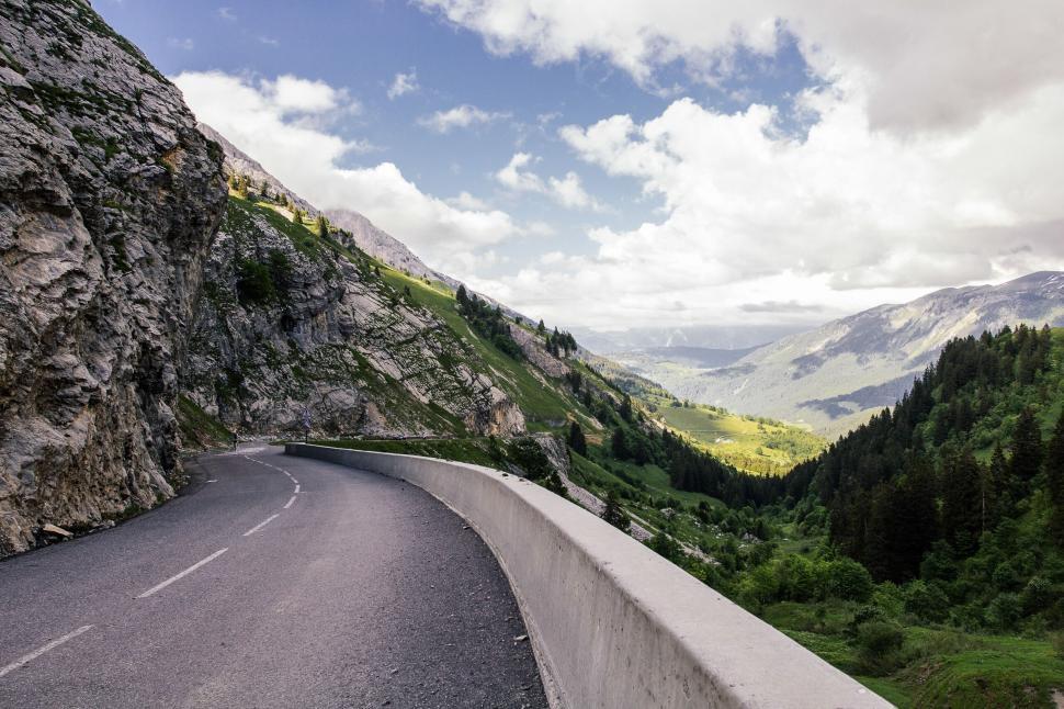 Free Image of A road with trees and mountains in the background 