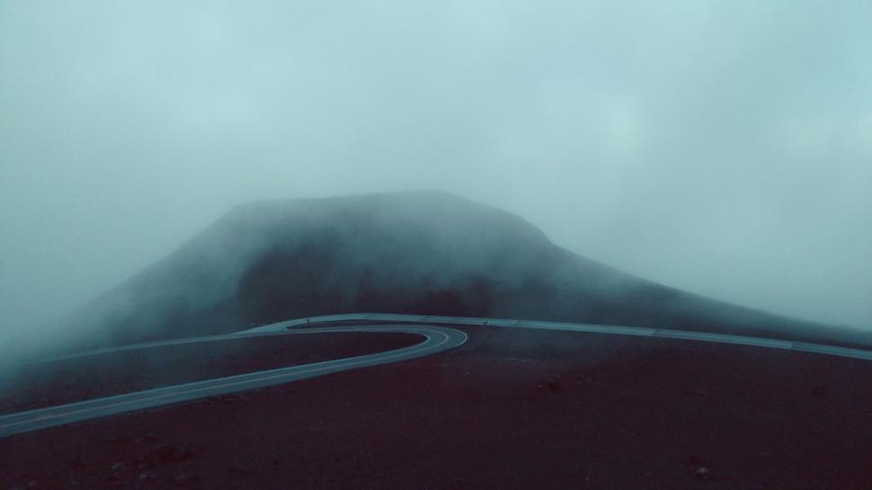 Free Image of A road going through a foggy mountain 