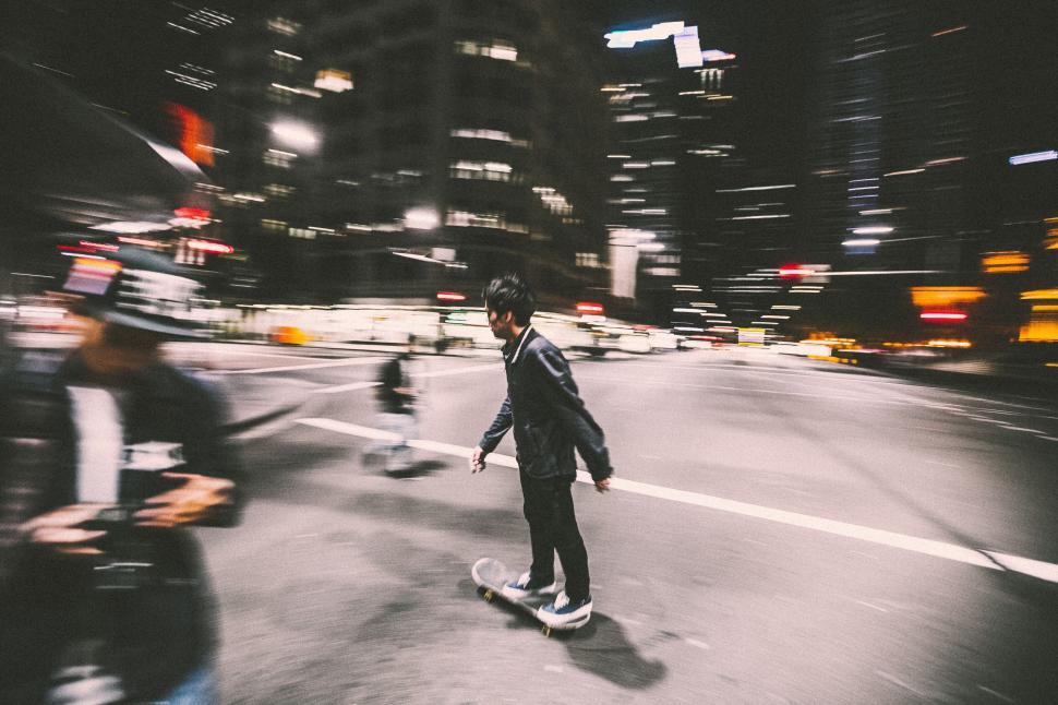 Free Image of A man riding a skateboard on a street 