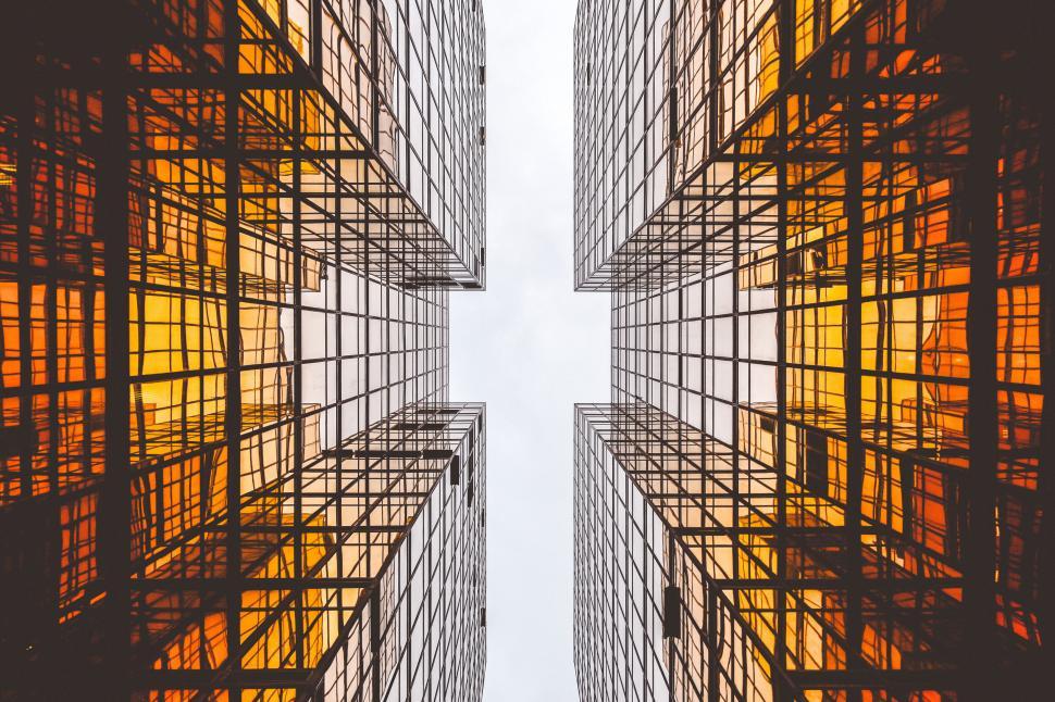 Free Image of Looking up view of a tall building with glass windows 