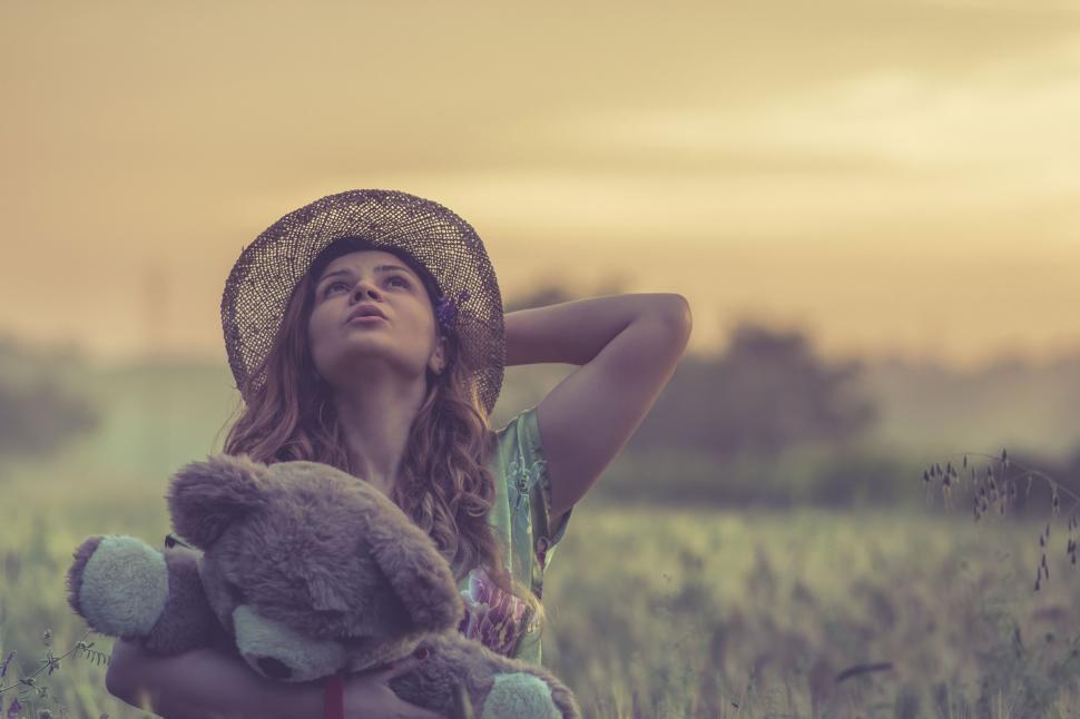Free Image of A woman holding a teddy bear in a field 