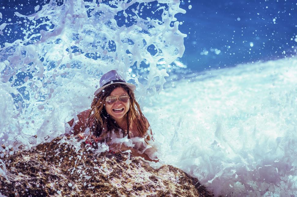 Free Image of A woman in a hat and sunglasses in the water 