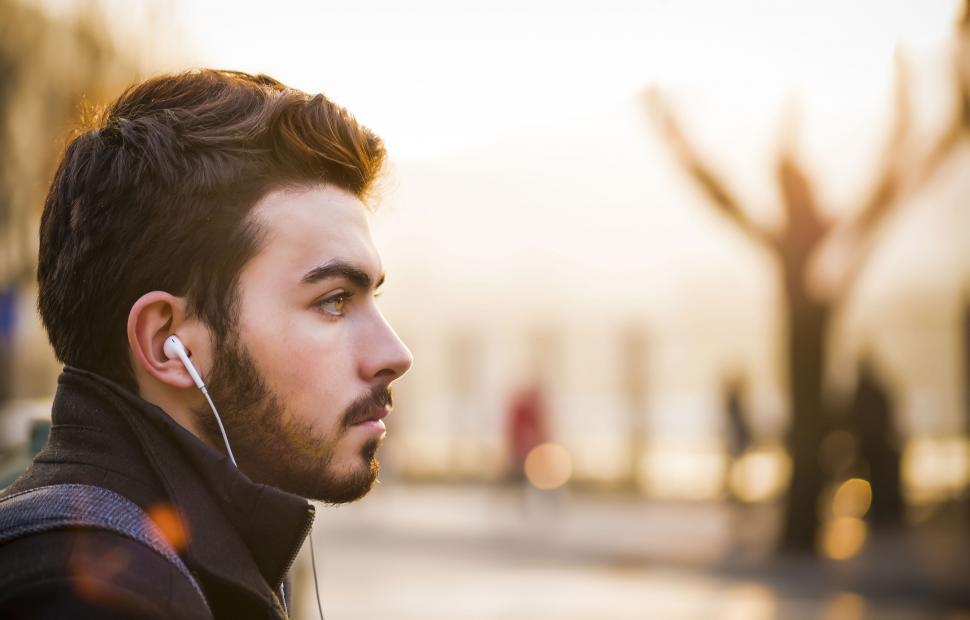 Free Image of A man with earphones in his ear 