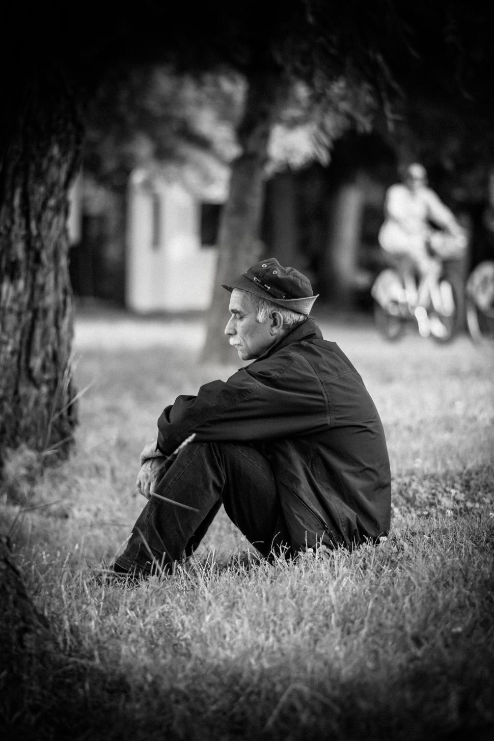 Free Image of A man sitting in the grass 