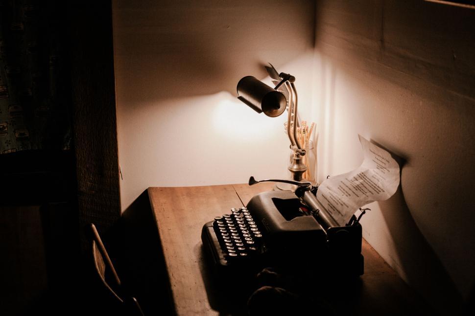 Free Image of A typewriter on a desk with a lamp 