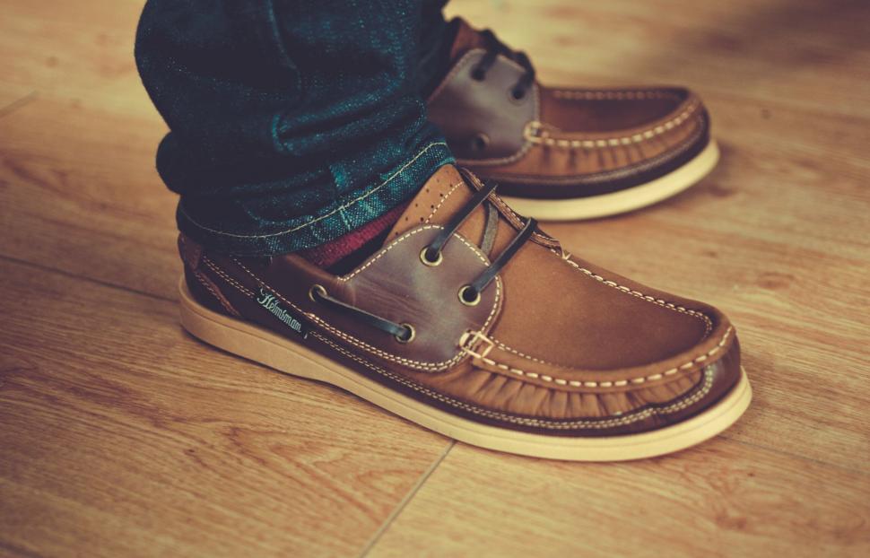 Free Image of A person s feet wearing brown shoes 