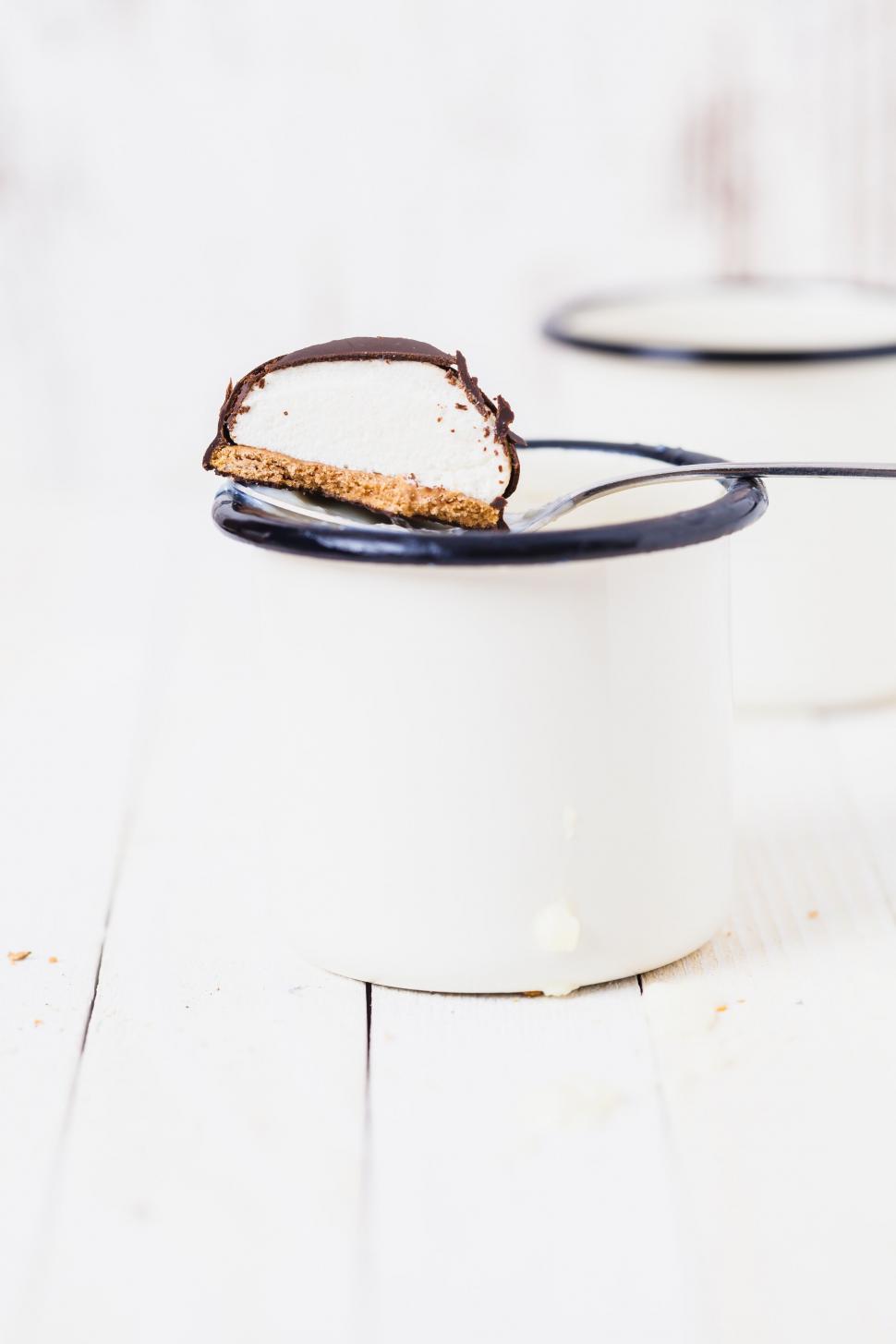 Free Image of A spoon in a mug with a piece of cheesecake 