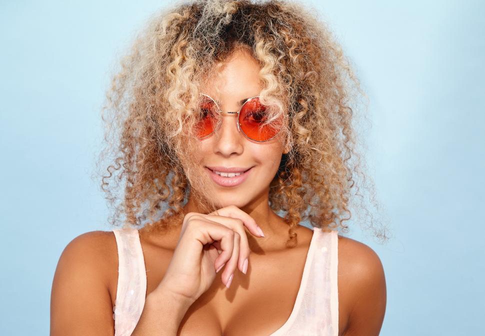 Free Image of A woman with curly blonde hair wearing sunglasses 