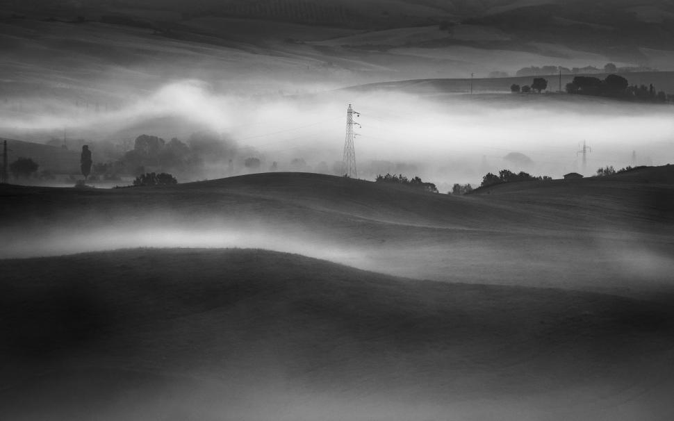 Free Image of A foggy landscape with trees and hills 