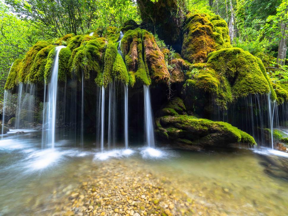Free Image of A waterfall over mossy rocks 