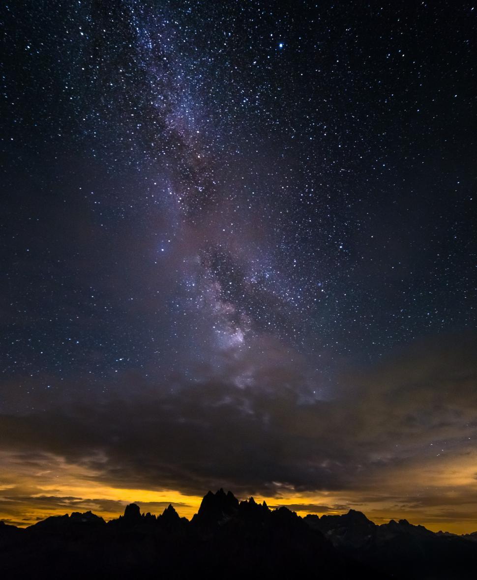 Free Image of A starry sky over a mountain range 