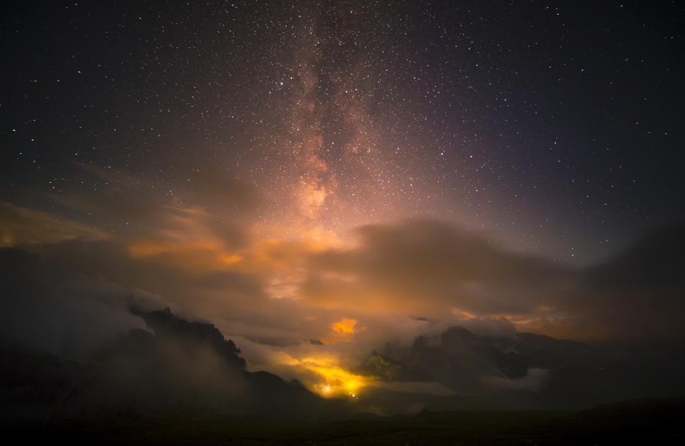 Free Image of A starry sky with clouds and a light in the sky 