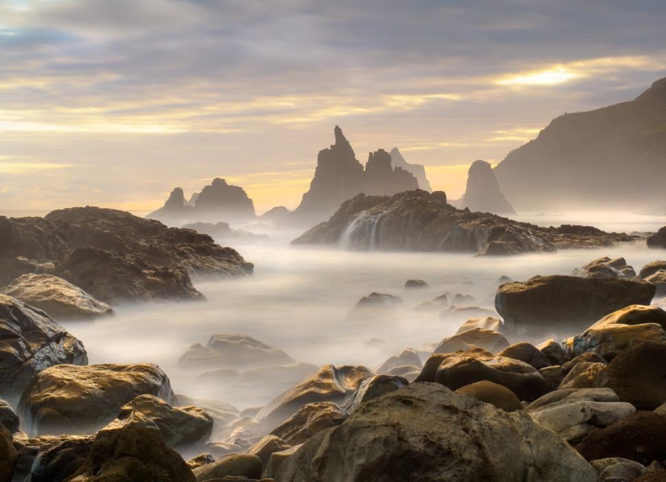 Free Image of A rocky beach with water flowing over rocks 