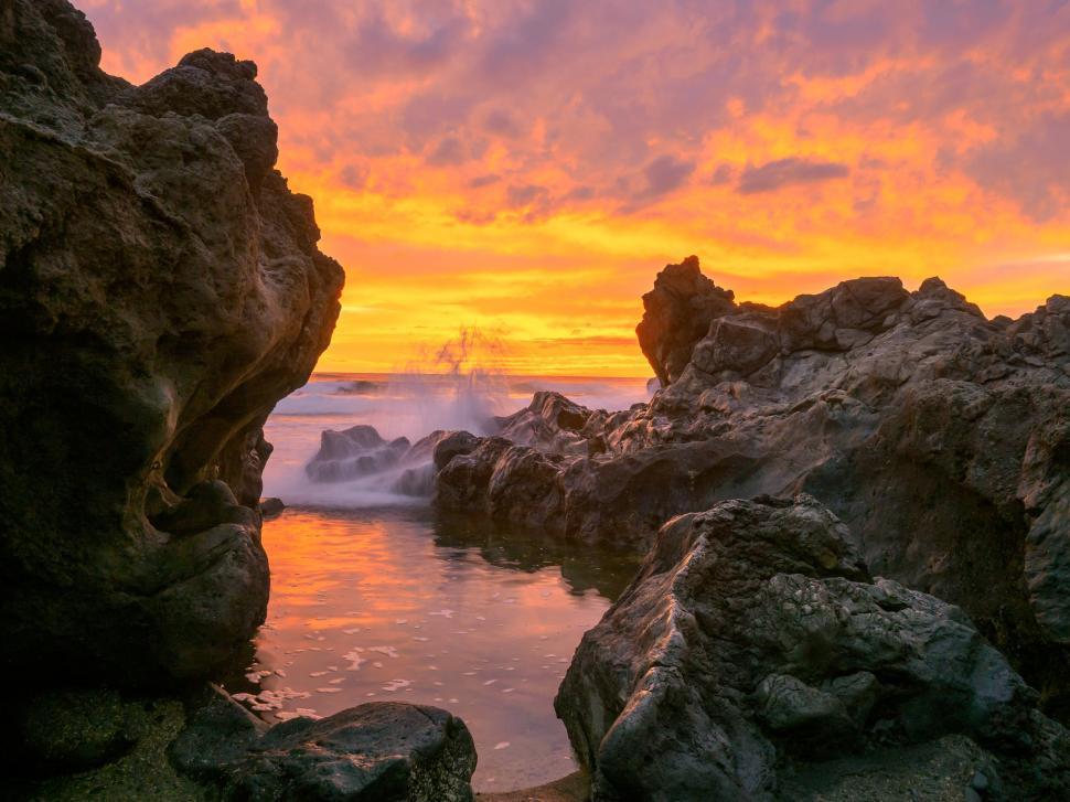 Free Image of A rocky beach with a sunset 
