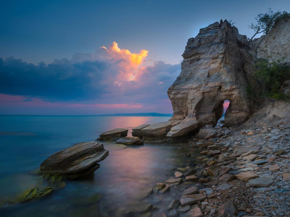 Free Image of A rocky beach with a large rock formation 