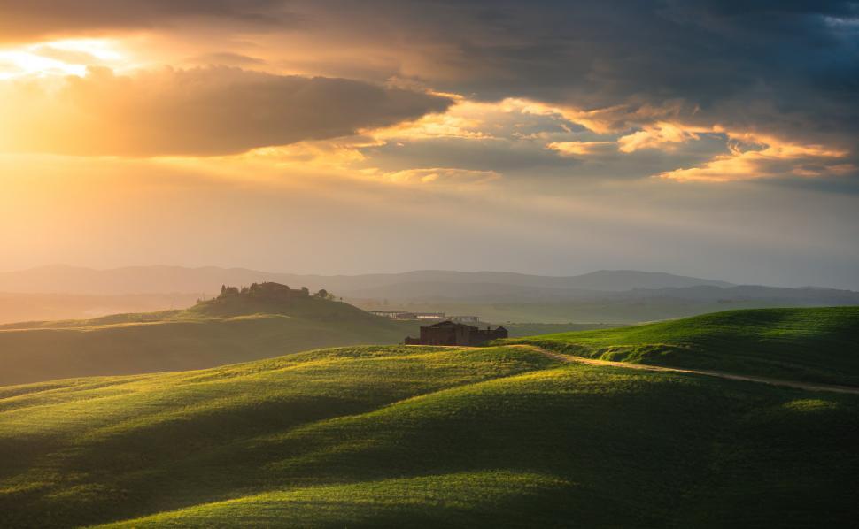 Free Image of A green rolling hills with a house in the distance 