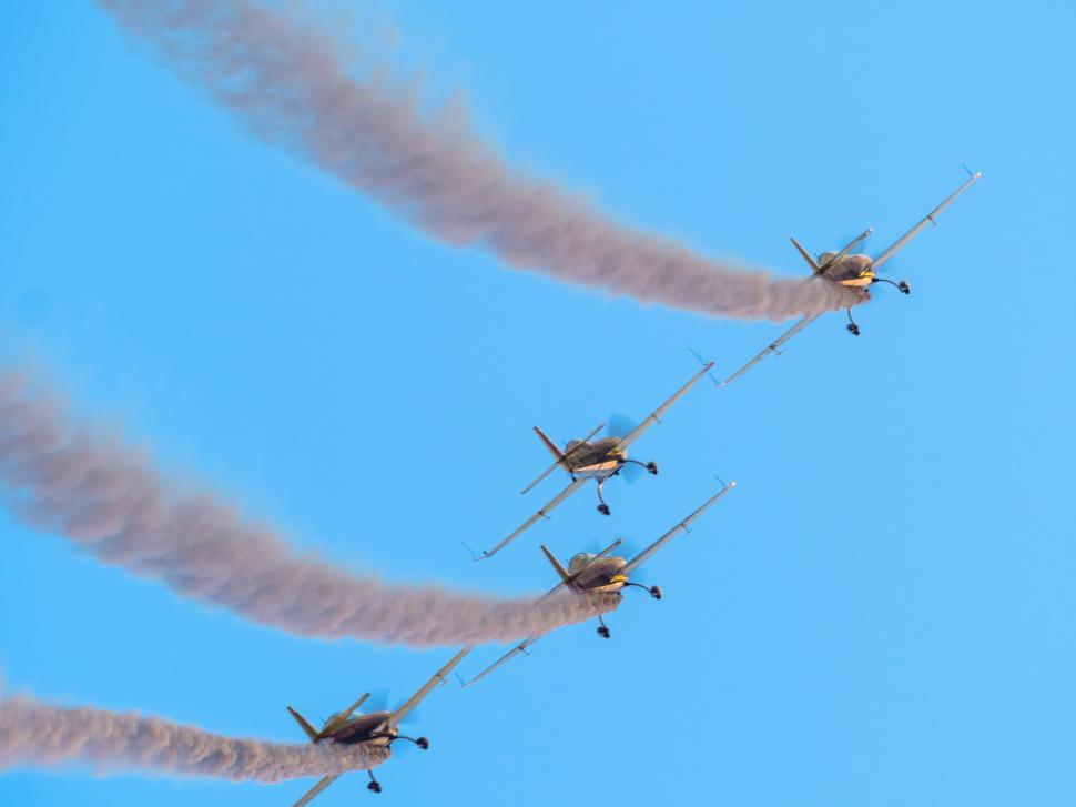 Free Image of A group of airplanes flying in formation with smoke trails 