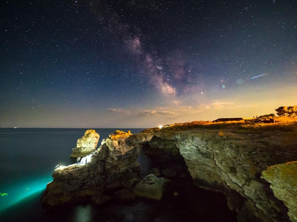 Free Image of A rocky cliff with lights at night 