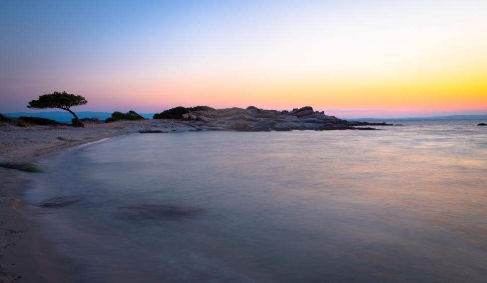 Free Image of A body of water with rocks and a beach 