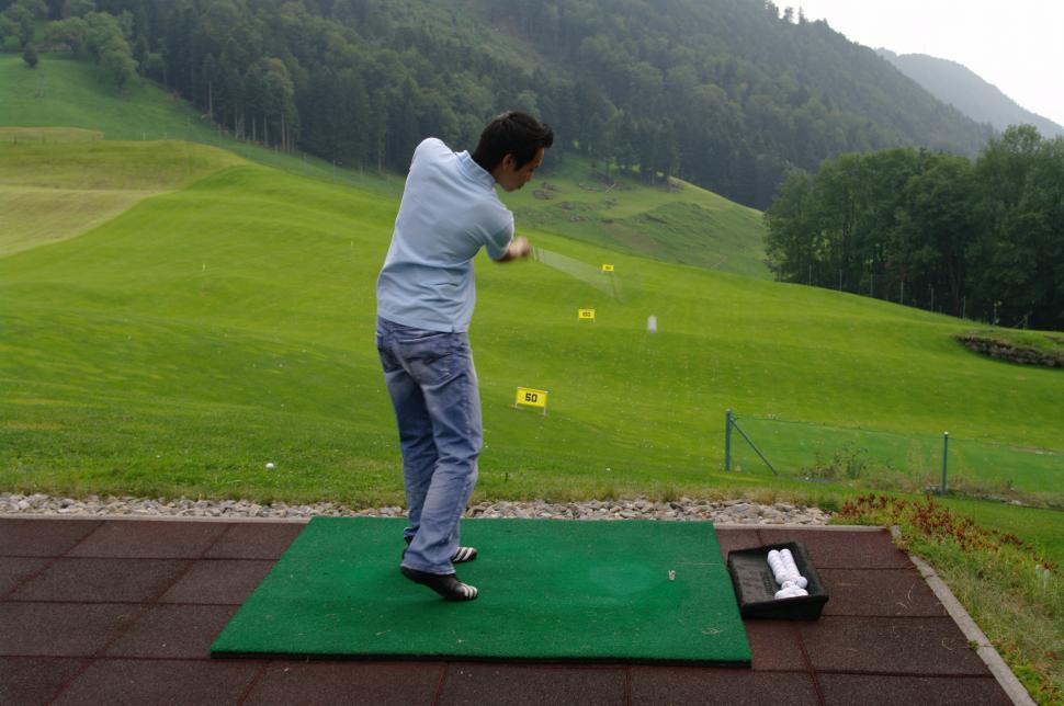 Free Image of Man Hitting Golf Ball With Golf Club 