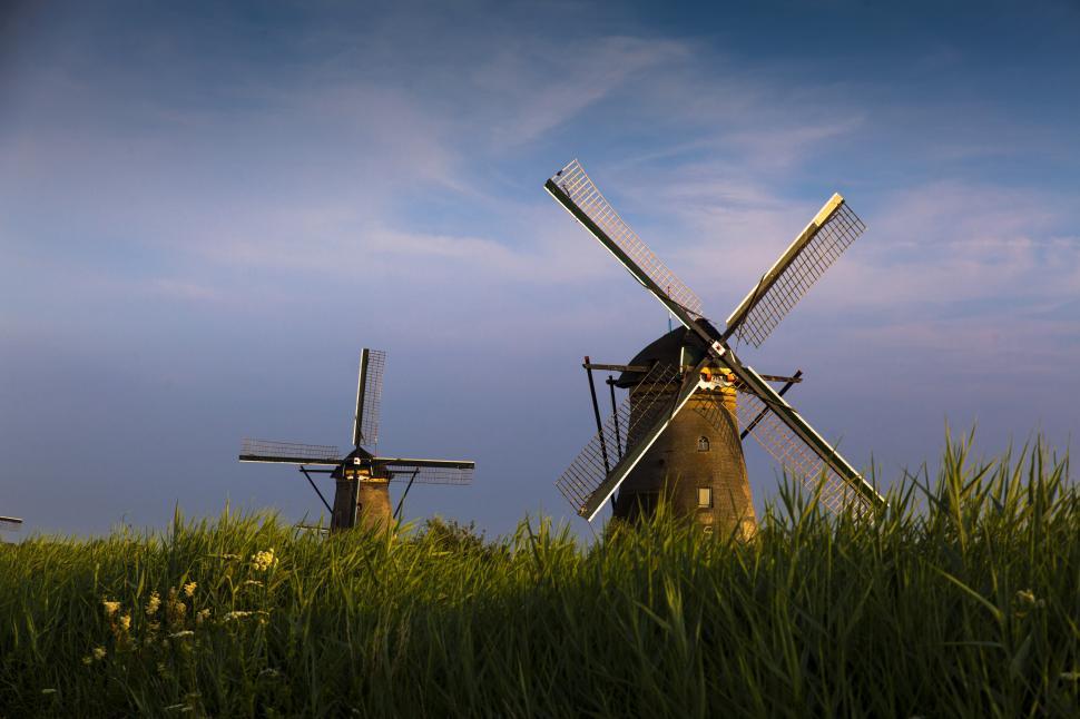 Free Image of Windmills in a field with grass and blue sky 