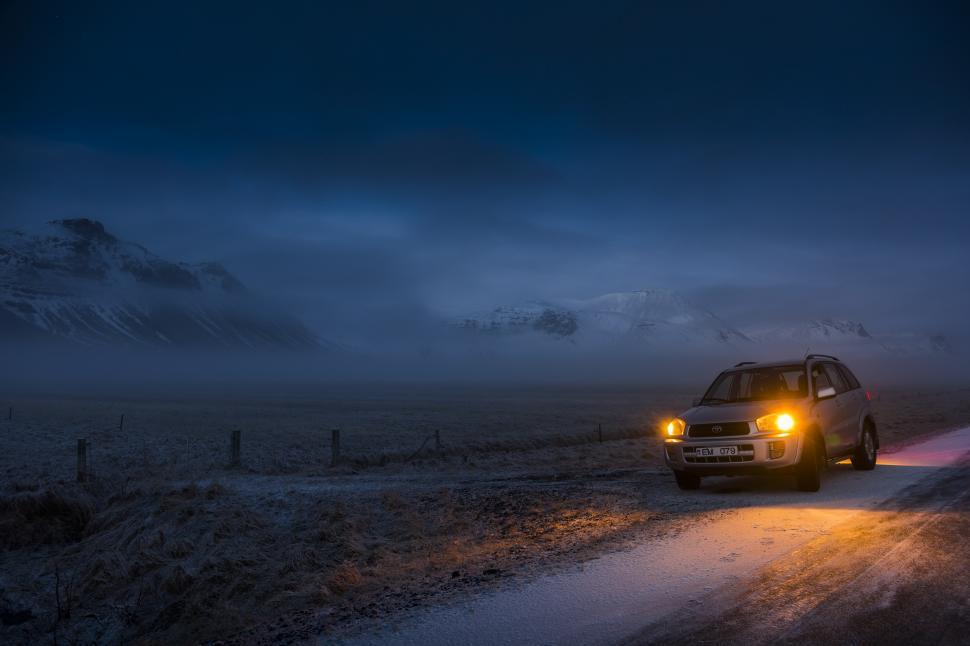 Free Image of A car with headlights on a snowy road 