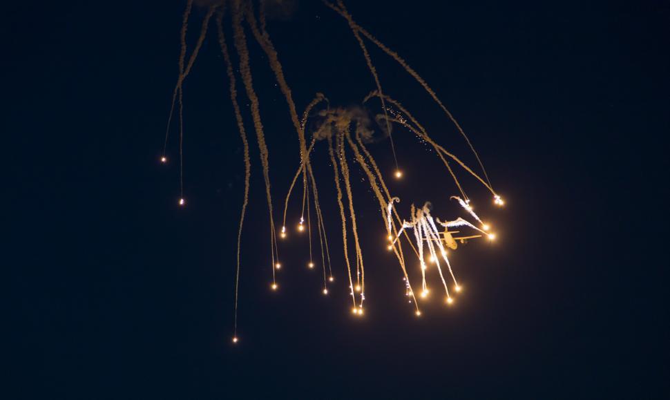 Free Image of A jet flying in the sky with fireworks 