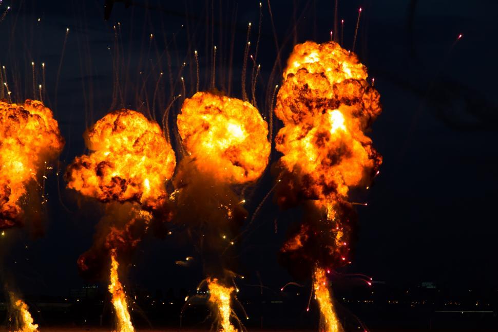 Free Image of A group of explosions in the sky with bonfires of saint john in the background 