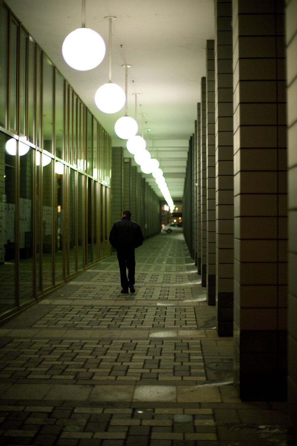 Free Image of A man walking down a walkway 