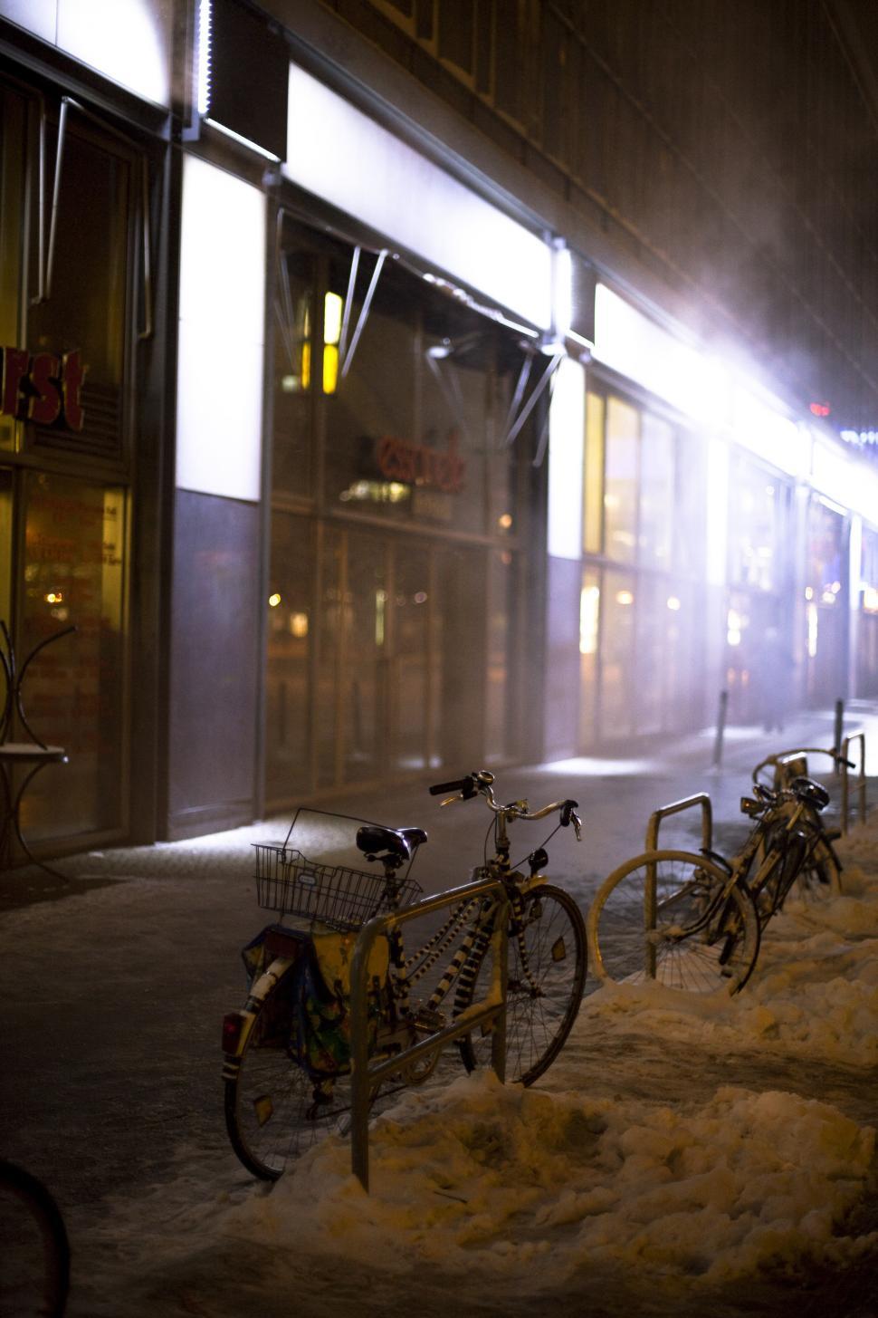 Free Image of Bicycles parked on a sidewalk in the snow 