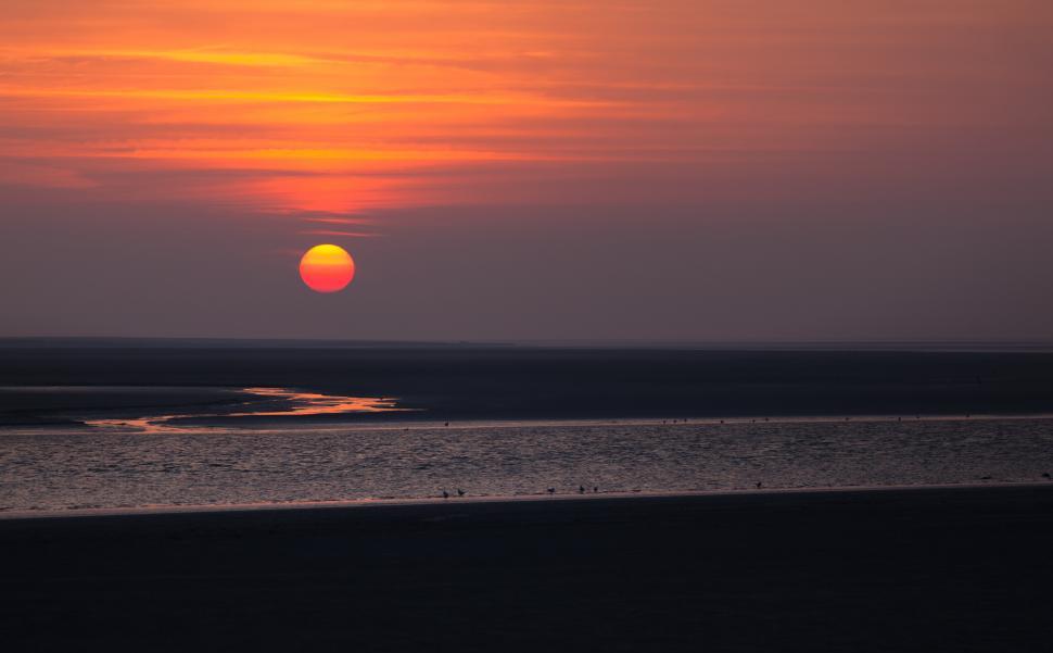Free Image of A sunset over a beach 