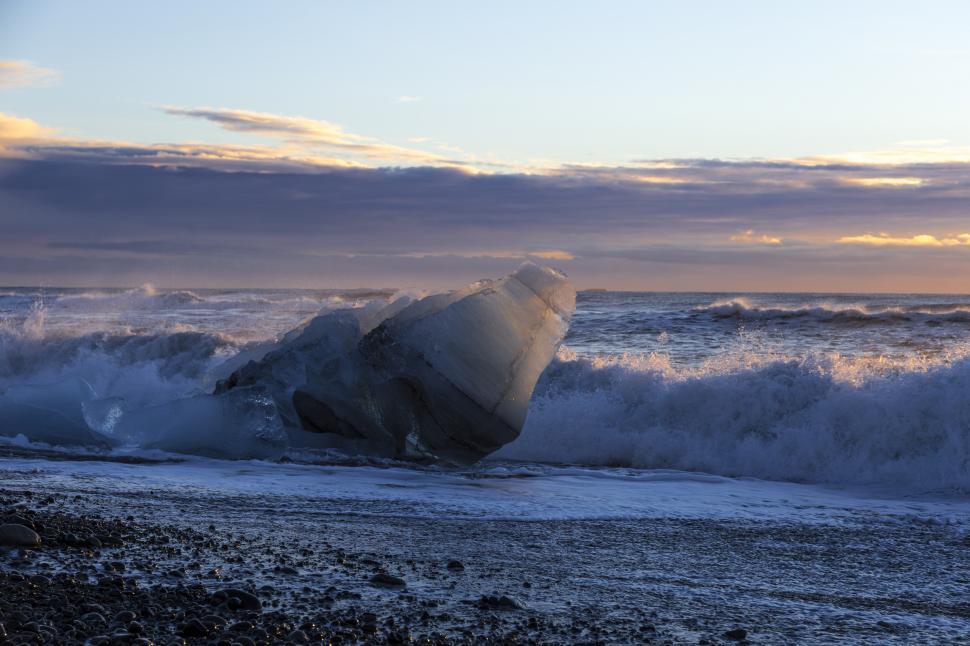 Free Image of A large iceberg on a beach 
