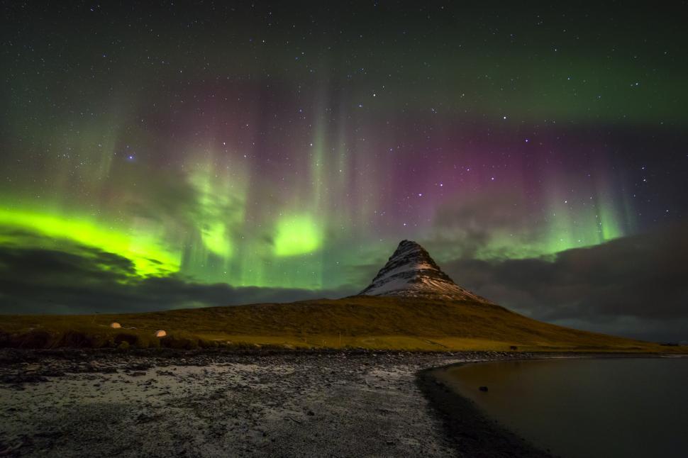 Free Image of A mountain with green lights in the sky 
