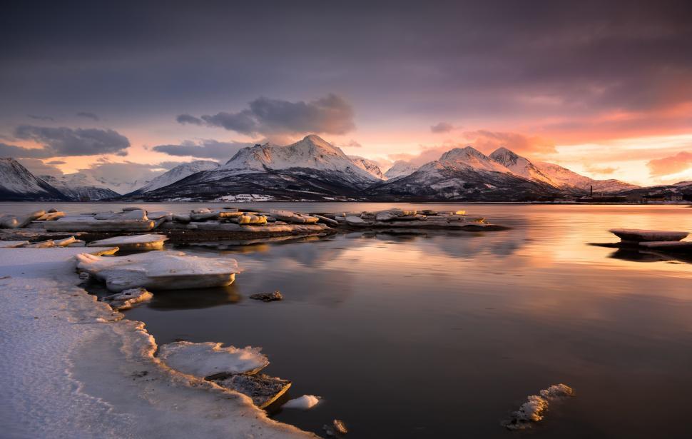 Free Image of A body of water with snow and mountains in the background 