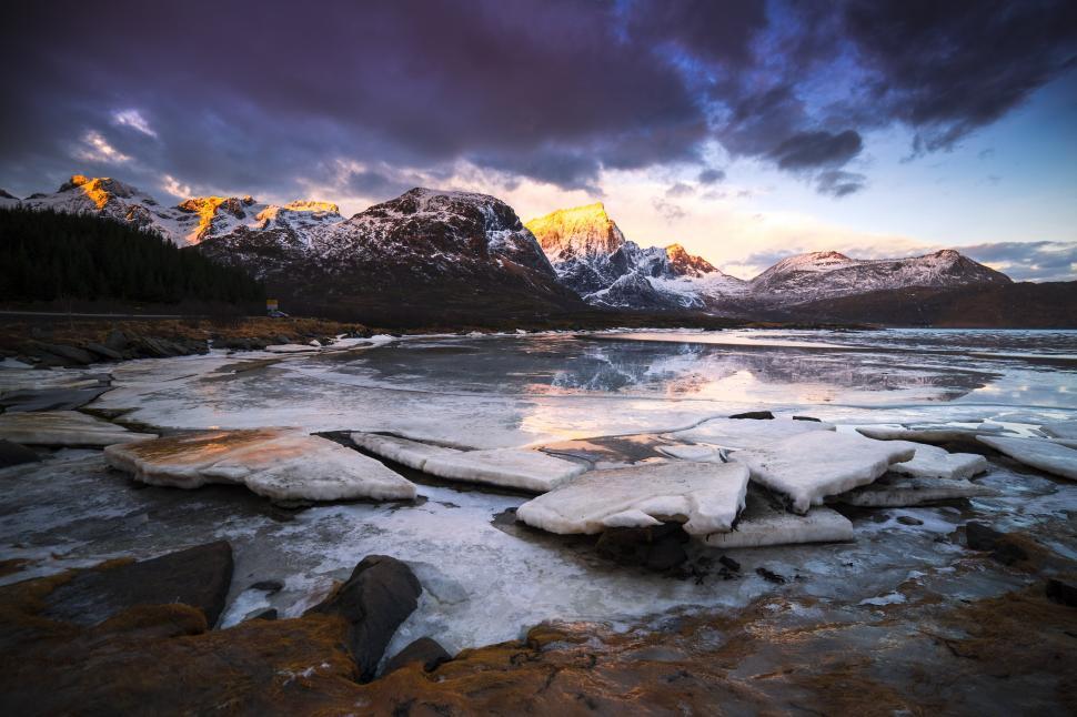 Free Image of A frozen lake with mountains in the background 