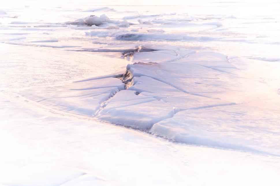 Free Image of A snow covered ground with cracks 