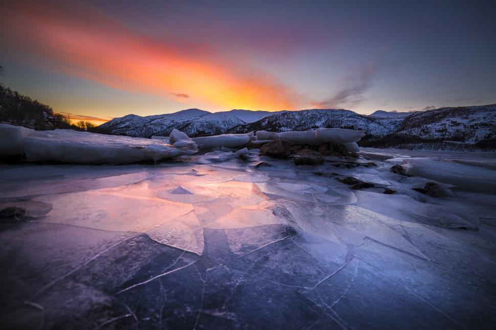 Free Image of A frozen lake with mountains in the background 
