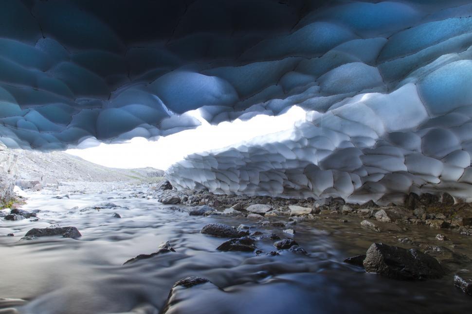 Free Image of A river flowing through a cave with ice 