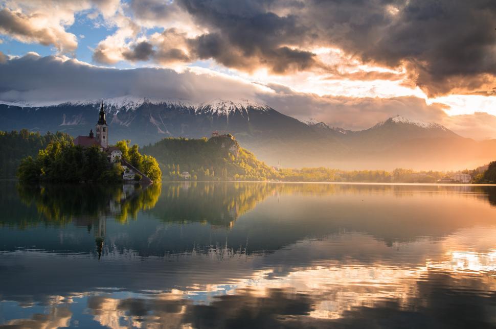 Free Image of A building on a lake with mountains in the background 