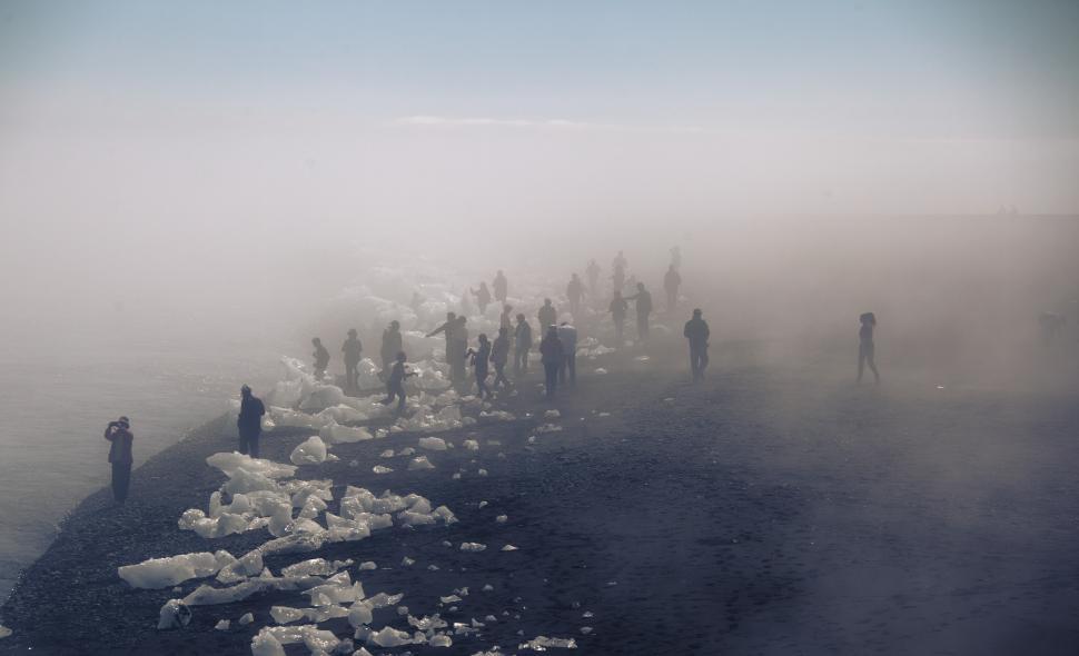 Free Image of A group of people walking on a beach with ice 