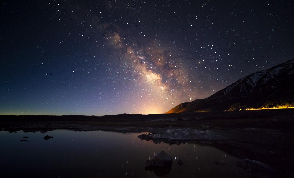 Free Image of A lake with a mountain and stars in the sky 