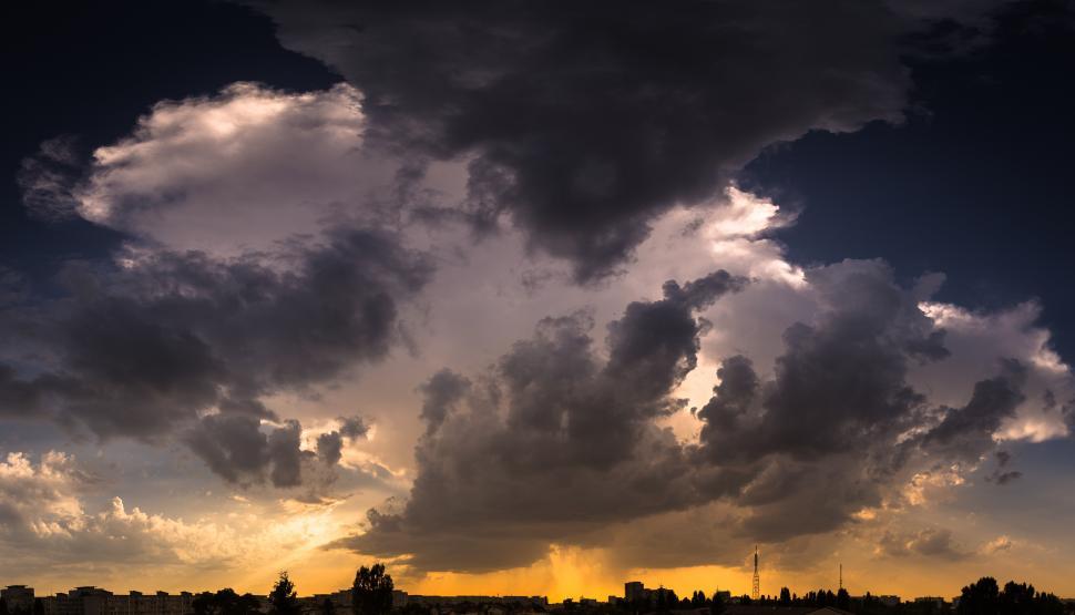 Free Image of A cloudy sky with a silhouette of a city 
